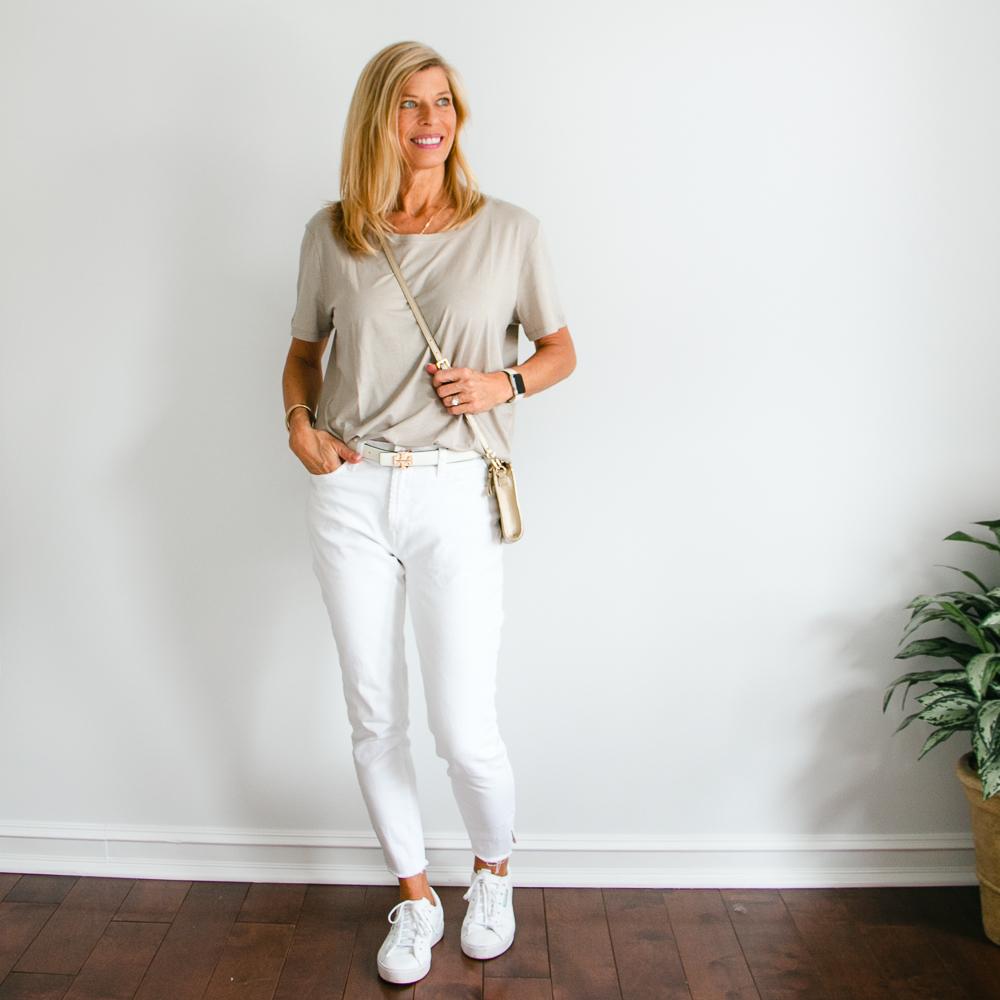 light taupe t-shirt with tapered jeans and adidas sneakers